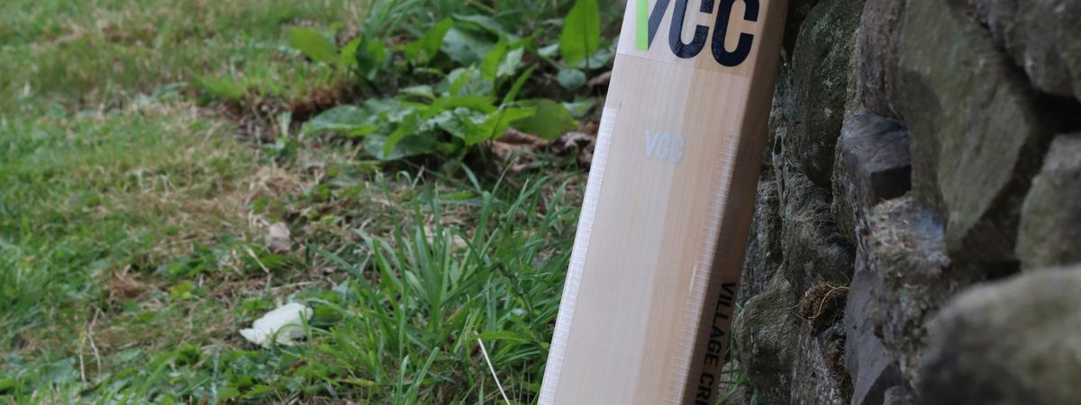 A cricket bat leaning on a stone wall