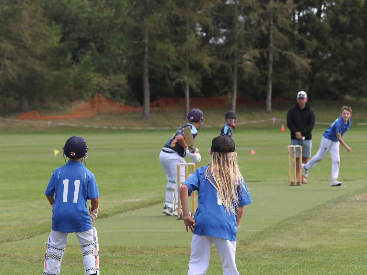 A Taupō bowler running in with fielders ready