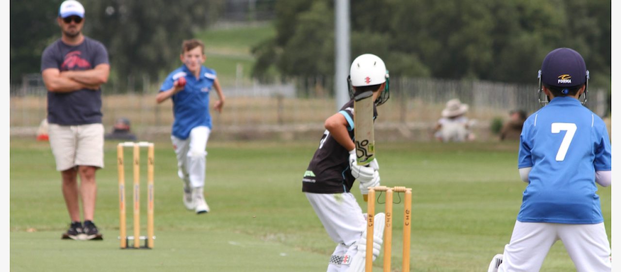 A Taupō junior game with batter, bowler, wicketkeeper and umpire